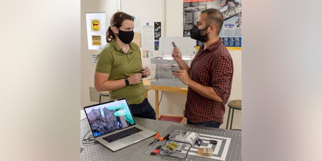 Elizabeth Hyde, a research engineer with the United States Geological Survey, and Alex Mazhari, head of the Space Shop’s Rapid Prototyping Lab, discussing the otter tag project in the Space Shop at NASA’s Ames Research Center. The tag itself is pictured on an otter on the laptop screen.