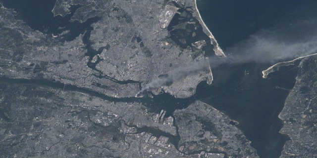 Visible from space, a smoke plume rises from the Manhattan area after two planes crashed into the towers of the World Trade Center. This photo was taken of metropolitan New York City (and other parts of New York as well as New Jersey) the morning of September 11, 2001. "Our prayers and thoughts go out to all the people there, and everywhere else," said Station Commander Frank Culbertson of Expedition 3, after the terrorists' attacks.