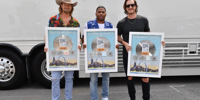 Brian Kelley and Tyler Hubbard of Florida Georgia Line and Nelly, center, take photos with their Platinum Single for ‘LilBit’ during CMT Crossroads: Nelly & Friends at The Factory At Franklin on September 01, 2021 in Franklin, Tenn.