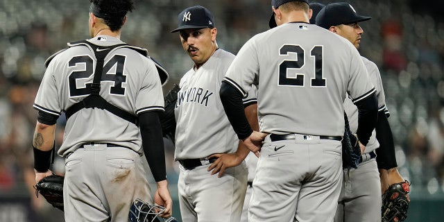 New York Yankees starting pitcher Nestor Cortes Jr., second from left, looks on from the mound moments before being pulled from the game against the Baltimore Orioles during the seventh inning of a baseball game, Woensdag, Sept.. 15, 2021, in Baltimore.