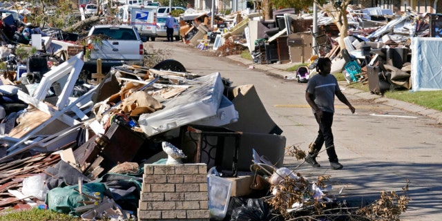 Lyndell Scott walks past the debris of his gutted home in the aftermath of Hurricane Ida in LaPlace, La., Friday, Sept. 10, 2021.