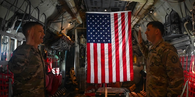 U.S. Army Col. Timothy MacDonald, operations director, Combined Joint Task Force - Horn of Africa, re-administers the Oath of Enlistment to Sgt. 1st Class Nathan Phelps, military police officer, CJTF-HOA, from Locke, New York, while aboard a KC-130J over East Africa, Sept. 11, 2021. The reenlistment occurred while flying over a Patriot’s Day ceremony at Camp Lemonnier, Djibouti, commemorating the 20th anniversary of the terrorist attacks on the United States on Sept. 11, 2001. Phelps extended his enlistment indefinitely while completing his third overseas deployment in support of the Global War on Terror. The ground ceremony included a joint formation, a multi-aircraft flyover, presentation of colors and the playing of Taps. Camp Lemonnier held multiple events in honor and remembrance of those who lost their lives both on that day and over the past two decades fighting the Global War on Terror. 