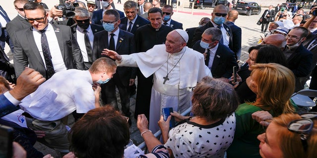 Pope Francis blesses an unidentified man as he greets the crowd while leaving the Cathedral of Saint Martin, in Bratislava, Slovakia, on Monday. (AP)