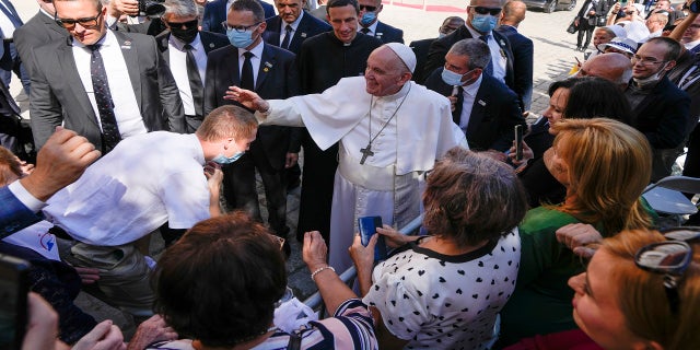 Pope Francis blesses an unidentified man as he greets the crowd while leaving the Cathedral of Saint Martin, in Bratislava, Slovakia, on Monday. (AP)