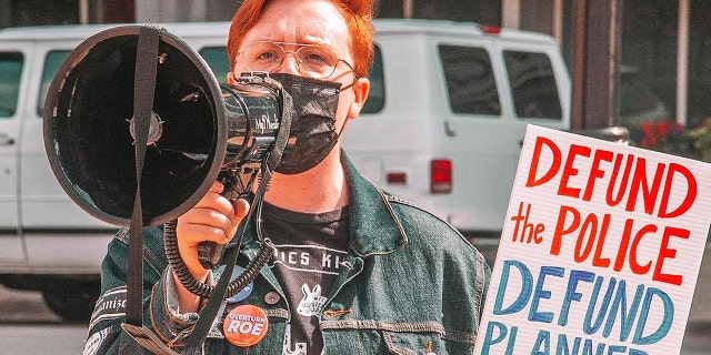 Herb Geraghty, executive director of Rehumanize International, speaks in a megaphone.