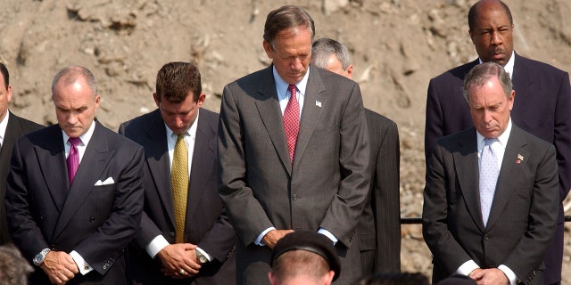 (L TO R) New York Police Commissioner Raymond Kelly, New York Governor George Pataki and New York Mayor Michael Bloomberg bow their heads at a memorial service for those killed during the September 11 attacks at the World Trade Center July 15, 2002, at Fresh Kills Landfill in the New York City borough of Staten Island. (Photo by Spencer Platt/Getty Images)