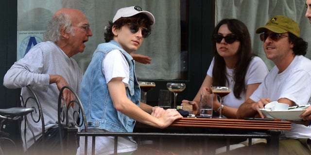 Timothée Chalamet, Larry David and Larry's Daughter are spotted out to eat at Sant Ambroeus in New York City. Chalamet was dressed down from his recent Met Ball appearance, in a baseball cap, denim vest and flame patterned shorts.