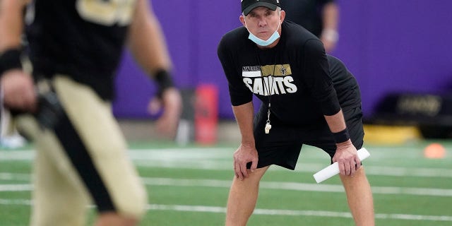 El entrenador en jefe de los New Orleans Saints, Sean Peyton, observa a los jugadores estirarse durante el entrenamiento de fútbol americano de la NFL en Fort Worth, Texas, el miércoles 15 de septiembre de 2021.  (Foto AP/LM Otero)