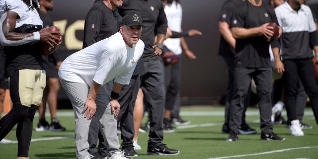 In this Sunday, 九月. 12, 2021, 档案照片, New Orleans Saints head coach Sean Payton, 从左数第二, watches players warm up before an NFL football game against the Green Bay Packers in Jacksonville, 弗拉.