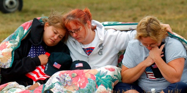 ADVANCE FOR PUBLICATION ON SUNDAY, SEPT. 5, AND THEREAFTER - FILE - In this Wednesday, Sept. 11, 2002 file photo, from left, Shannon Barry, Lisa Starr and Michelle Wagner, all of Hershey, Pa., comfort each other as they listen to a memorial service for victims of Flight 93 near Shanksville, Pa. President Bush will lay a wreath at the crash site later in the day to mark the anniversary of the terrorist attacks. 