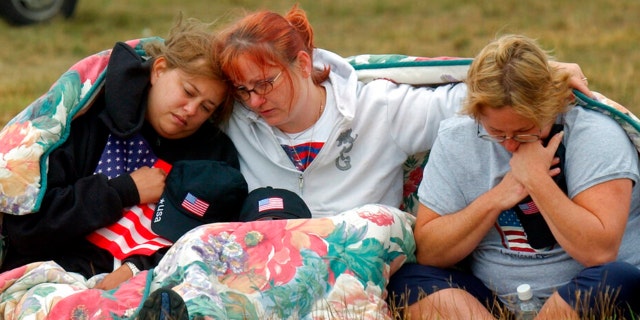 ADVANCE FOR PUBLICATION ON SUNDAY, SEPT. 5, AND THEREAFTER - ファイル - In this Wednesday, 9月. 11, 2002 ファイル写真, 左から, Shannon Barry, Lisa Starr and Michelle Wagner, all of Hershey, 上手。, comfort each other as they listen to a memorial service for victims of Flight 93 near Shanksville, Pa. President Bush will lay a wreath at the crash site later in the day to mark the anniversary of the terrorist attacks.