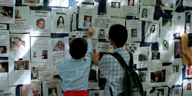 Two boys look at a poster of missing people outside Bellevue Hospital in the week after 9/11/01.
