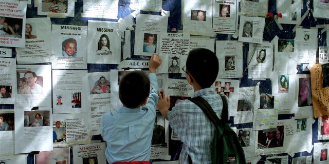 Two boys look at a poster of missing people outside Bellevue Hospital in the week after 9/11/01.