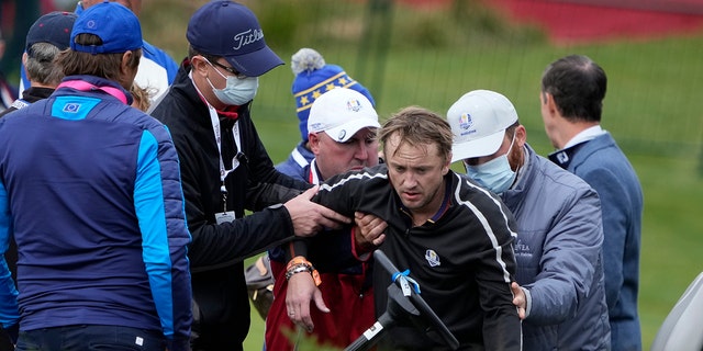 Actor Tom Felton is being helped after collapsing on the 18th hole during a practice day at the Ryder Cup at Whistling Straits Golf Course on Thursday, September 23, 2021, in Sheboygan, Wis.  (Associated Press)