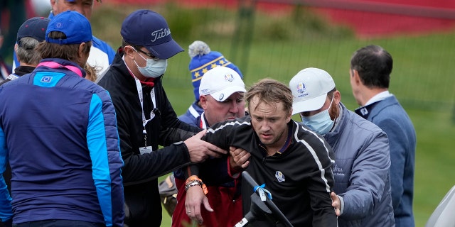 Actor Tom Felton is helped after collapsing on the 18th hole during a practice day at the Ryder Cup at the Whistling Straits Golf Course Thursday, Sept. 23, 2021, in Sheboygan, Wis. (Associated Press)