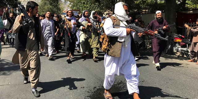 Taliban soldiers walk towards Afghans shouting slogans near the Pakistan embassy in Kabul, Afghanistan, Tuesday, Sept. 7, 2021. (AP Photo/Wali Sabawoon)