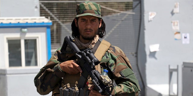 A Taliban soldier stands guard at the gate of Hamid Karzai International Airport in Kabul, Afghanistan, Sunday, Sept. 5, 2021. Some domestic flights have resumed at Kabul's airport, with the state-run Ariana Afghan Airlines operating flights to three provinces. (AP Photo/Wali Sabawoon)