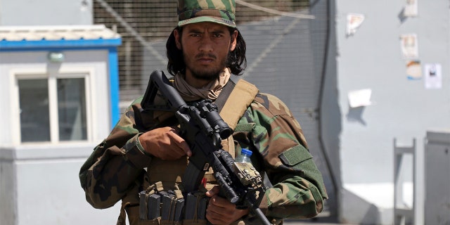 A Taliban soldier stands guard at the gate of Hamid Karzai International Airport in Kabul, Afghanistan, Sunday, Sept. 5, 2021. Some domestic flights have resumed at Kabul's airport, with the state-run Ariana Afghan Airlines operating flights to three provinces. (AP Photo/Wali Sabawoon)