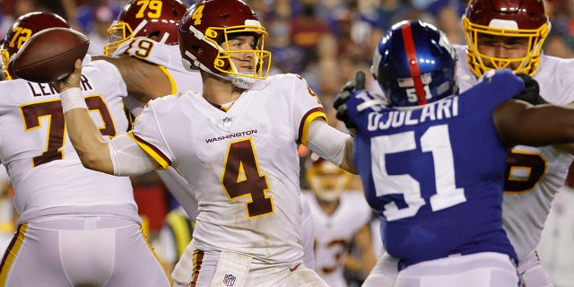 Washington Football Team quarterback Taylor Heinicke (4) passes the ball as New York Giants linebacker Azeez Ojulari (51) defends in the fourth quarter at FedExField.