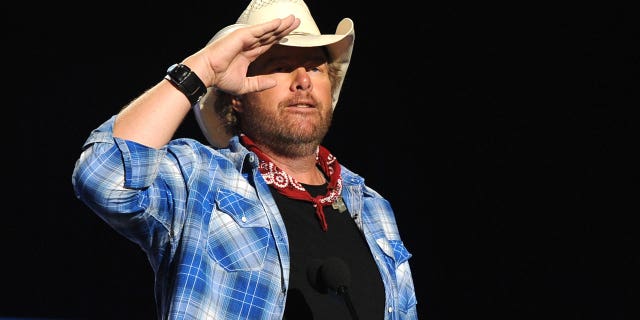  Musician Toby Keith accepts USO award onstage during ACM Presents: An All-Star Salute To The Troops at the MGM Grand Garden Arena on April 7, 2014 in Las Vegas, Nevada.