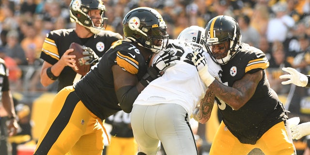 Pittsburgh Steelers Chuckwuma Okorafor, left, and guard Trai Turner slow down Las Vegas Raiders defensive end Maxx Crosby as quarterback Ben Roethlisberger throws a fourth quarter touchdown at Heinz Field.  The Raiders won the game 26-17.