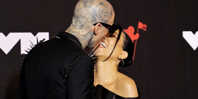 Travis Barker and Kourtney Kardashian share a kiss on the 2021 MTV Video Music Awards red carpet.