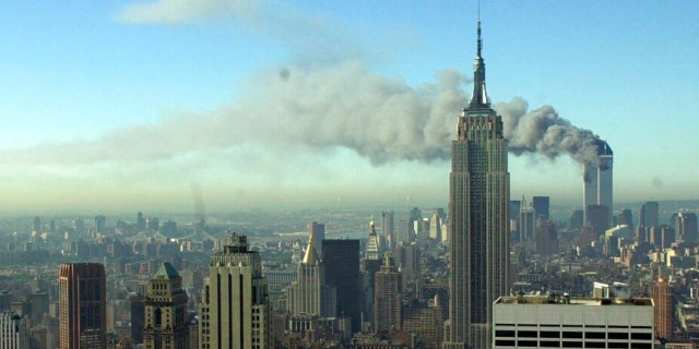 FILE - The twin towers of the World Trade Center burn behind the Empire State Building, Tuesday Sept. 11, 2001. in New York. 