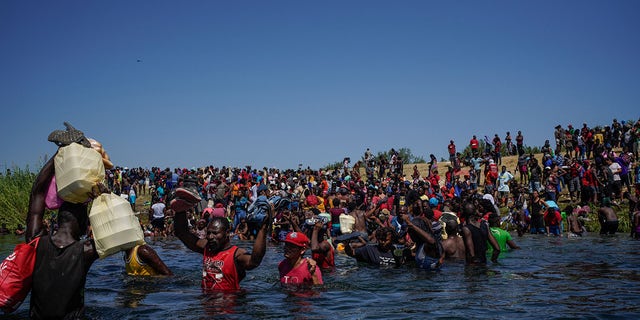 Haitian migrants, part of a group of over 10,000 people staying in an encampment on the U.S. side of the border, cross the Rio Grande to get food and water in Mexico, after another crossing point was closed near the Acuna Del Rio International Bridge in Del Rio, Texas on Sept. 19, 2021. 
