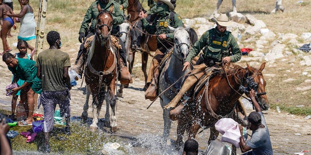 U.S. Customs and Border Protection mounted officers attempt to contain migrants as they cross the Rio Grande from Ciudad Acuña, Mexico, into Del Rio, Texas, Sept. 19, 2021.