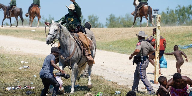 A United States Border Patrol agent on horseback tries to stop a Haitian migrant from entering an encampment on the banks of the Rio Grande near the Acuna Del Rio International Bridge in Del Rio, Texas on Sept. 19, 2021.