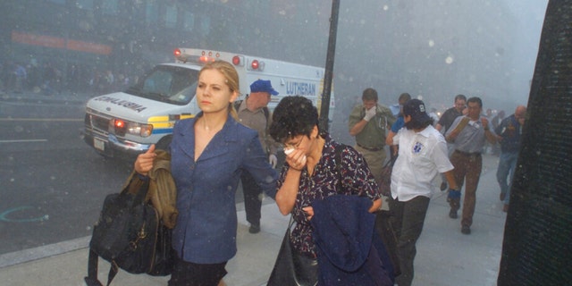 FILE - People flee from downtown Manhattan after planes crashed into the twin towers of the World Trade Center on September 11, 2001 in New York City. Associated Press photographer Richard Drew talks about AP’s coverage of 9/11 and the events that followed. 
