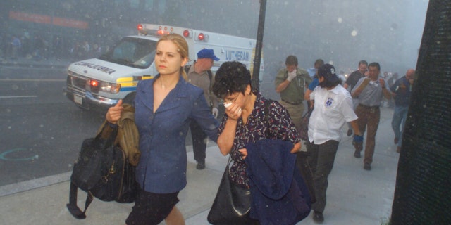 FILE - People flee from downtown Manhattan after planes crashed into the twin towers of the World Trade Center on September 11, 2001 in New York City. Associated Press photographer Richard Drew talks about AP’s coverage of 9/11 and the events that followed.