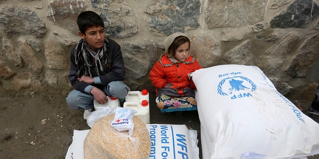 In this Jan. 24, 2017 file photo, children wait for transportation after receiving food donated by the World Food Program, in Kabul, Afghanistan. On Friday, Oct. 9, 2020 the WFP won the 2020 Nobel Peace Prize for its efforts to combat hunger and food insecurity around the globe. 
