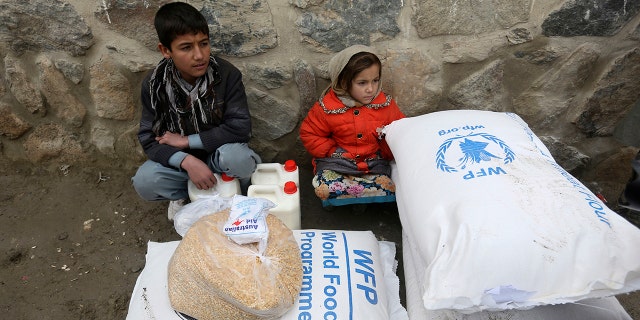 FILE - In this Jan. 24, 2017 file photo, children wait for transportation after receiving food donated by the World Food Program, in Kabul, Afghanistan. On Friday, Oct. 9, 2020 the WFP won the 2020 Nobel Peace Prize for its efforts to combat hunger and food insecurity around the globe. 