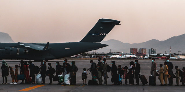 Evacuees wait to board an Air Force C-17 Globemaster III during an evacuation at Hamid Karzai International Airport in Kabul, Afghanistan, on Aug. 23, 2021.