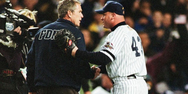 President George W. Bush shakes hands with New York Yankees wide receiver Todd Greene before pitching the first pitch before Game 3 of the World Series between the Arizona Diamondbacks and the New York Yankees on October 30, 2001 at the Yankee Stadium in the Bronx, New York York. (Photo by Sporting News via Getty Images via Getty Images)