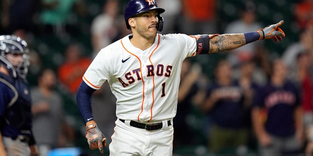 Houston Astros' Carlos Correa (1) celebrates after hitting a game-winning RBI ground-rule double against the Seattle Mariners during the 10th inning of a baseball game Tuesday, Sept. 7, 2021, in Houston. The Astros won 5-4 in 10 innings. (AP Photo/David J. Phillip)