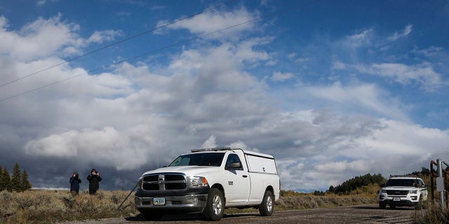 An unmarked coroner's vehicle, front, drives past members of the media waiting in the Spread Creek area of the Bridger-Teton National Forest, just east of Grand Teton National Park off U.S. Highway 89 in Wyoming, Sunday, Sept. 19, 2021. Authorities say a body discovered is believed to be Gabrielle "Gabby" Petito. The FBI said the body was found by law enforcement agents who had spent the past two days searching campgrounds. (AP Photo/Amber Baesler)