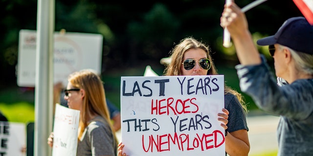 A sign held by a healthcare worker reads "Last Year's Heroes, This Year's Unemployed" at a protest at St. Catherine of Siena Hospital in Smithtown, New York, on Sept. 27, 2021.