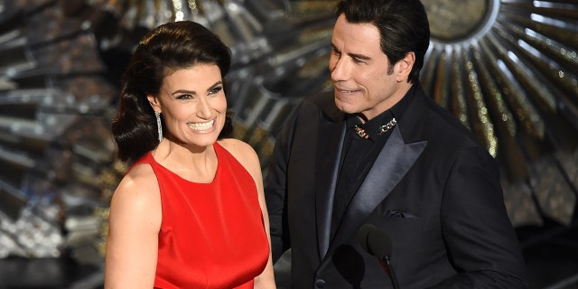 John Travolta (R) and Idina Menzel present an award on stage at the 87th Oscars February 22, 2015 in Hollywood, California.