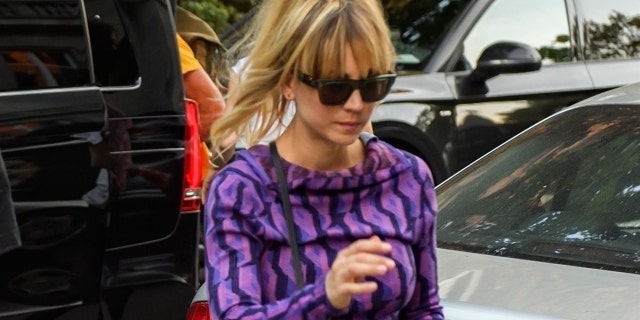 Actress Kaley Cuoco looks trendy in a purple patterned top as she is pictured arriving to her hotel in Berlin to film 'The Flight Attendant.'