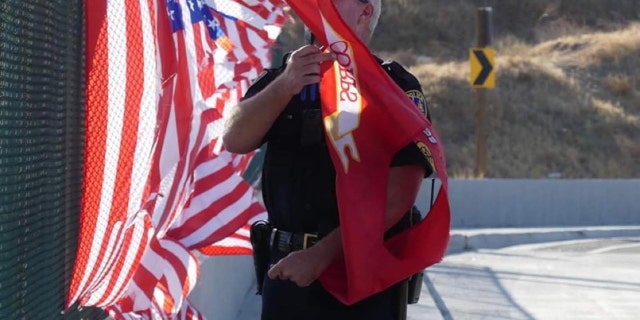 The memorial of 13 American flags and one Marine Corps flag was displayed on the fence of the Ivy Street overpass above the 91 Freeway in Riverside