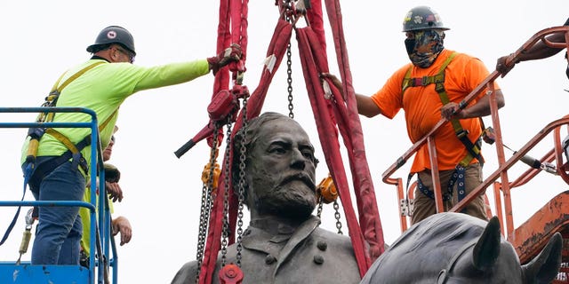 Crews work to remove a towering statue of Confederate Gen. Robert E. Lee on Monument Avenue in Richmond, Virginia, on Sept. 8, 2021. 