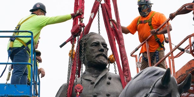 Crews work to remove one of the country's largest remaining monuments to the Confederacy, a towering statue of Confederate General Robert E. Lee on Monument Avenue, Wednesday, Sept. 8, 2021, in Richmond, Va. (AP Photo/Steve Helber, Pool)