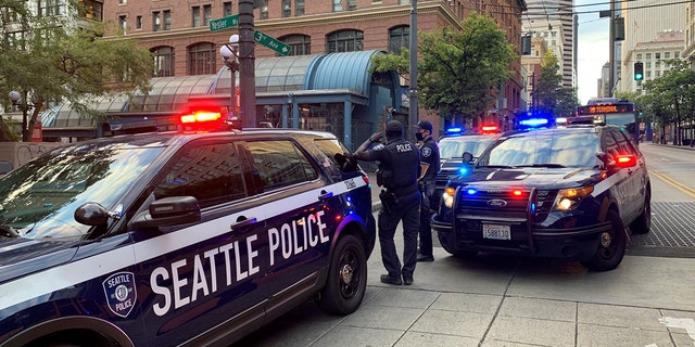 FILE - SEPTEMBER 1, 2021: Seattle police respond to a third shooting incident Tuesday night in the 200 block of Yesler Way in the Pioneer Square neighborhood.