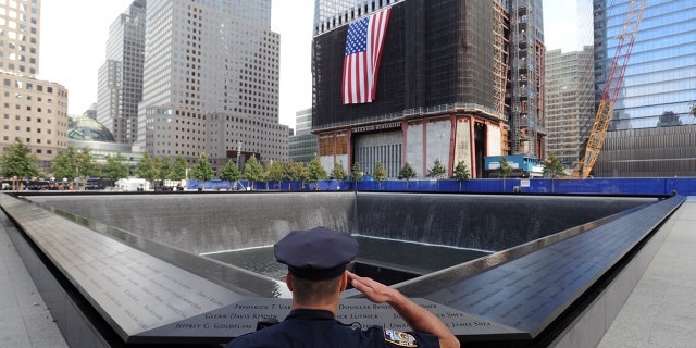 New York City Police Officer Danny Shea, a military vet, salutes at the North pool of the 9/11 Memorial during the tenth anniversary ceremonies of the September 11, 2001, terrorist attacks at the World Trade Center site, September 11, 2011, in New York City.