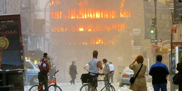 People walk in the street in the area where the World Trade Center buildings collapsed Sept. 11, 2001. 