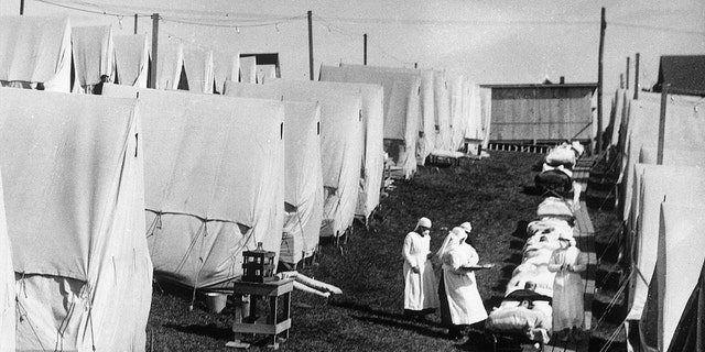 1918: Nurses care for victims of a Spanish influenza epidemic outdoors amidst canvas tents during an outdoor fresh air cure, Lawrence, Massachusetts. (Photo by Hulton Archive/Getty Images)
