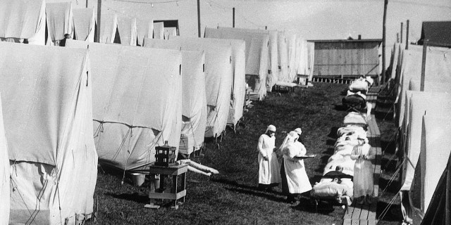 1918: Nurses care for victims of a Spanish influenza epidemic outdoors amidst canvas tents during an outdoor fresh air cure, Lawrence, Massachusetts. (Photo by Hulton Archive/Getty Images)
