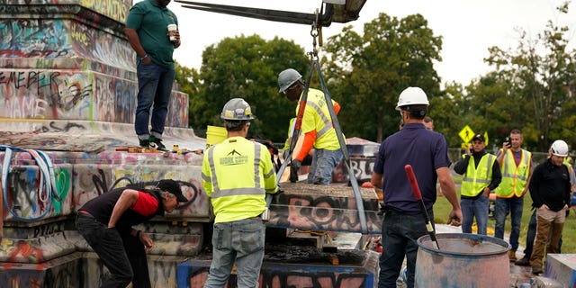 Crews move a section of the base as they attempt to locate a time capsule said to be buried in the base of the statue of on Monument Avenue in Richmond, Va., Thursday, Sept. 9, 2021.